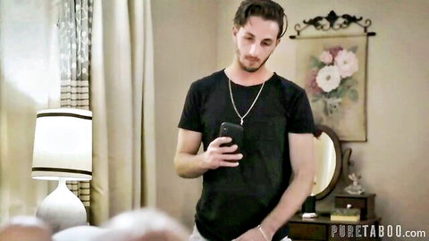 Intense young man in black t-shirt holding phone in Pure Taboo scene