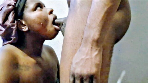 Ebony woman in headwrap giving intense blowjob to standing man