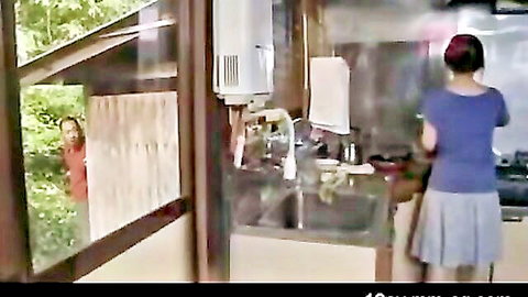 Asian housewife in short skirt at kitchen sink, spied by lover outside