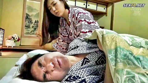 Japanese brunette in kimono massages man's back on bed intensely