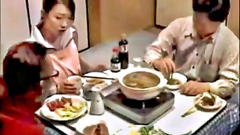 Japanese wife and lover intimately sharing hot pot dinner at table