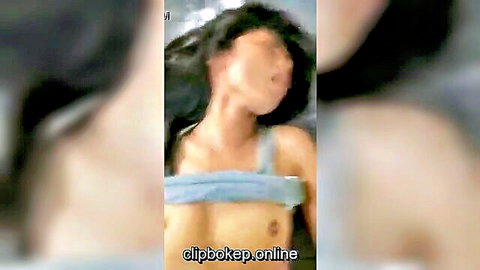 Asian woman with long black hair moaning pleasurably, breasts exposed in steamy affair video