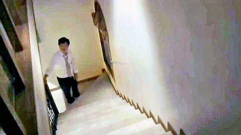 Korean man in white shirt and tie walking down stairs in Young Mother 3 movie scene