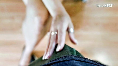Manicured hands with rings tugging down black pants waistband teasing cock