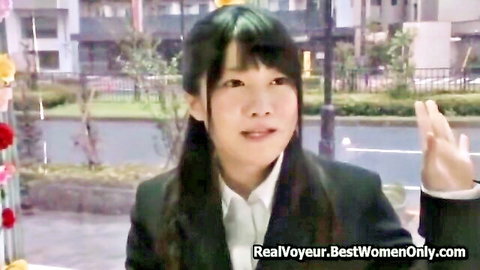 Young Japanese woman in school uniform smiling and waving outdoors