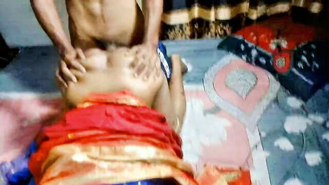 Muscular South Asian man fucks housewife in red sari missionary style, cock thrusting into wet pussy on bed