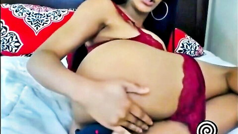 Pregnant ebony woman in red lingerie caressing her belly seductively