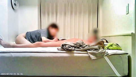 Blurry amateur Asian couple fucking sideways on bed, wife's bare ass and pussy exposed