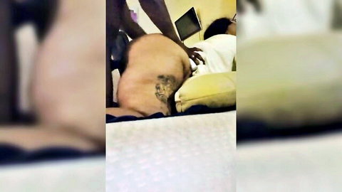 Big ass black man with tattoo grabbing ebony woman in rough doggy style position on bed