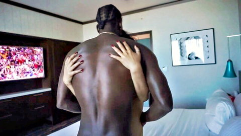 Muscular nude black man hugged passionately from behind by nude interracial woman in hotel room
