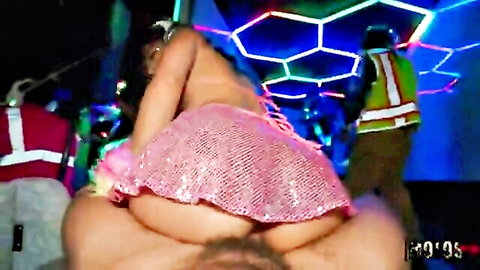 Big ass babe in sparkly pink skirt grinds on guy's lap at neon club party