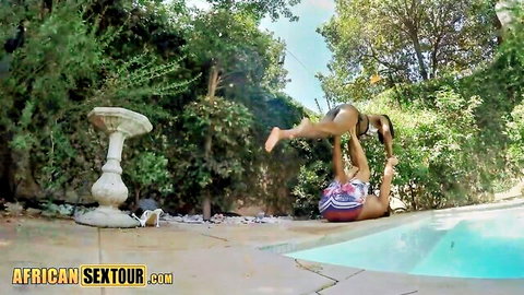 Two bikini babes poolside with one handstanding legs up showing juicy ass cheeks