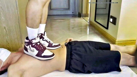 Muscular East Asian dom in maroon Nike Jordans trampling shirtless sub's bare chest in rough gay fetish