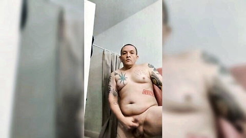 Tattooed chubby man posing nude solo