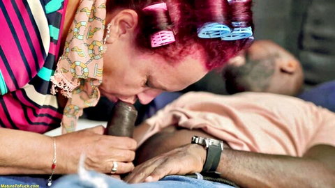 Redhead mature woman in curlers sucking massive black cock during interracial blowjob