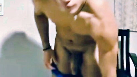 Muscular Asian man pulling down pants exposing erect cock and abs