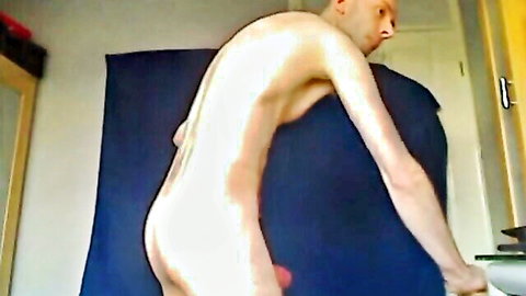 Bald naked man bends over from behind exposing hanging cock and balls in amateur solo