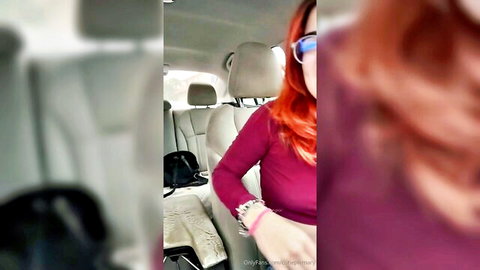 Amateur redhead with glasses taking selfies in car wearing pink top