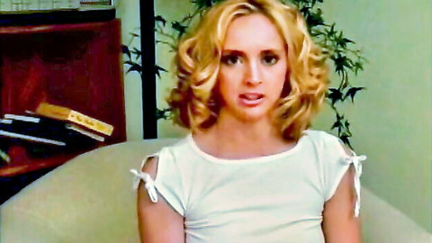 Blonde curly-haired woman in sexy white top on casting couch tease