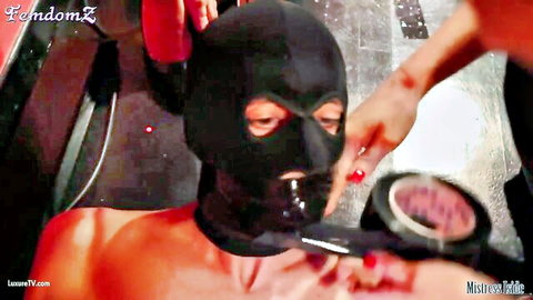 Mistress Iside applies tape gag to hooded muscular sub in BDSM domination
