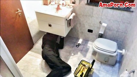 Plumber crawls under sink fixing pipes in tight apartment bathroom on MILF cheating hidden cam