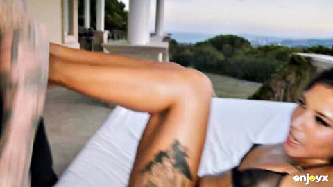 Petite Andrea Retali with tattoos lounging in lingerie outdoors