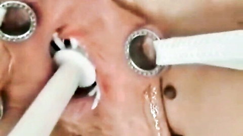 Close-up of pussy pierced with rings, penetrated by white toothbrush handles and dripping cum