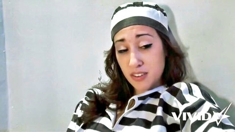 Sexy prison babe in striped inmate uniform pouting seductively with parted lips