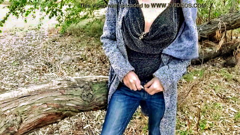 Mature woman in park teasing voyeur with hands on jeans