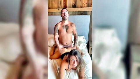 Tattooed bearded man grips naked brunette's ass prone bone doggy style on bed