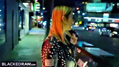 Kleio Valentien in sparkly studded leather jacket on neon-lit night street