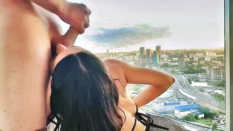 Brunette in sexy black lingerie passionately kissed by man with stunning city skyline view