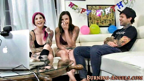 Tattooed punk girls laugh with inked guy in casual threesome setup