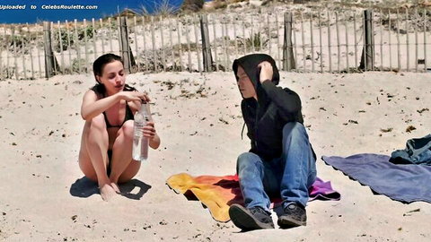 Maya Coline topless on beach pouring water in Jessica Forever scene