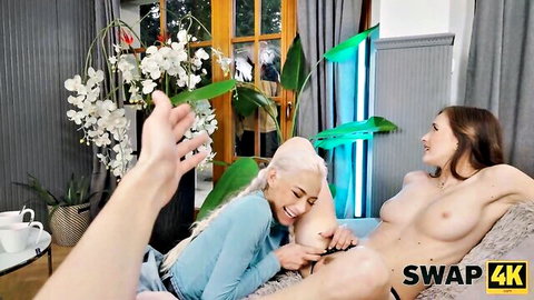 Platinum blonde in blue top fingers smiling topless brunette's pussy on couch