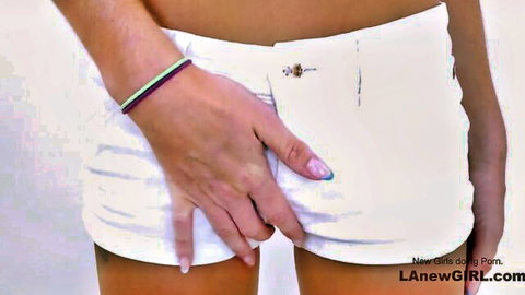 Lean babe in tight white shorts slides hand inside for intimate touch