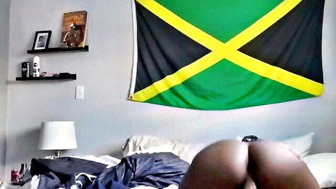 Curvy ebony babe with big round ass on bed, Jamaican flag backdrop