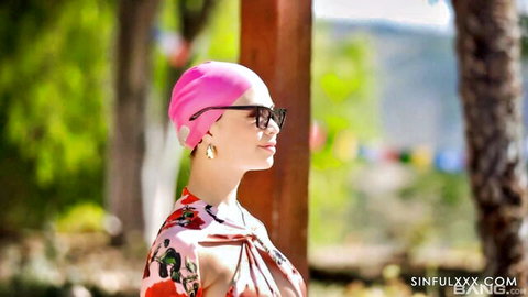 Tanned skinny brunette with small tits exposes perky nipples in pink swim cap and open floral robe poolside outdoors