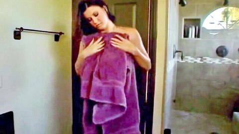Brunette babe clutching purple towel over wet tits in steamy shower bathroom tease