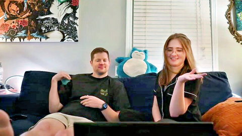 Smiling blonde with natural tits flirts on couch webcam beside boyfriend and Snorlax plush