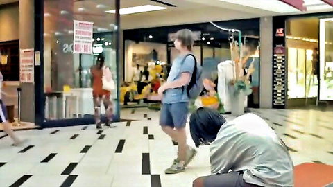 Amateur public mall scene with standing and kneeling figures in casual clothes