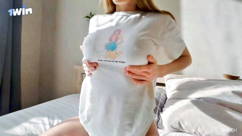 Blonde girlfriend lifts oversized t-shirt exposing perky breasts in teasing pose