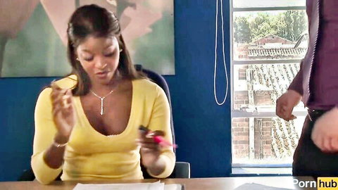 Sexy ebony babe in low-cut yellow top showing cleavage at office desk with man behind