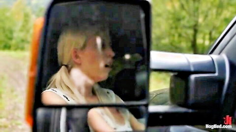 Blonde woman in ecstasy screaming in car with mirror reflection