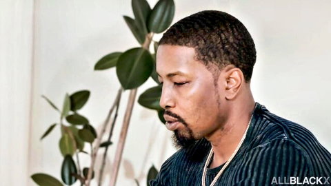 Handsome black man in profile with curly hair beard and green velvet shirt thoughtful pose