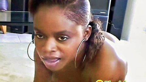 Ebony beauty with hoop earrings and ponytail in nude seductive pose