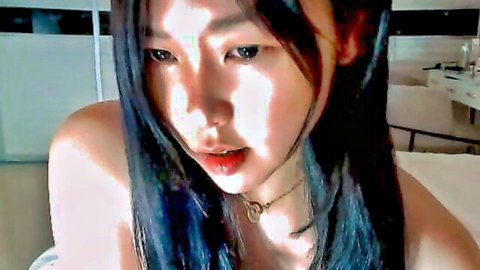 Seductive Asian webcam girl puckers plump lips bare shoulders tease