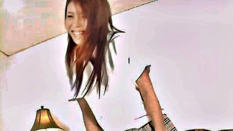 Smiling Japanese schoolgirl in white shirt and plaid skirt posing playfully