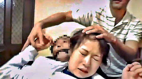 Japanese DILF grips taboo East Asian woman's head firmly as she lies back crying on bed