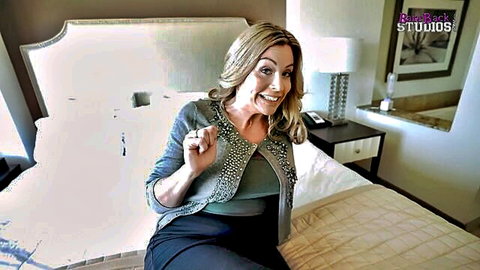 Busty Coco Vandi smiling seductively on bed, stepmom vacation tease